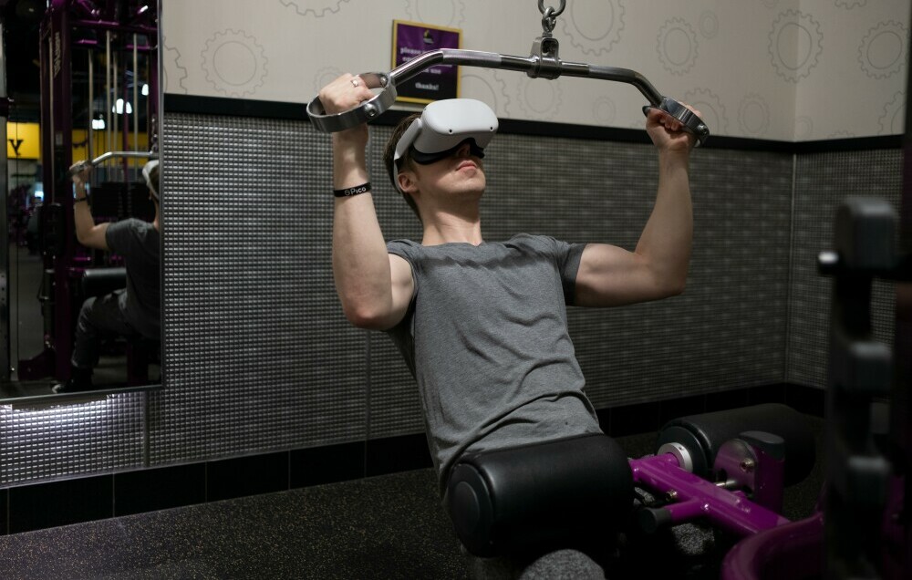 A Man Lifting Weights while Wearing Virtual Goggles