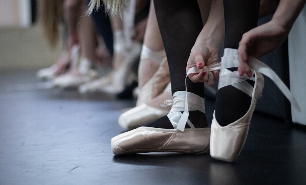 girl tying pointe shoe