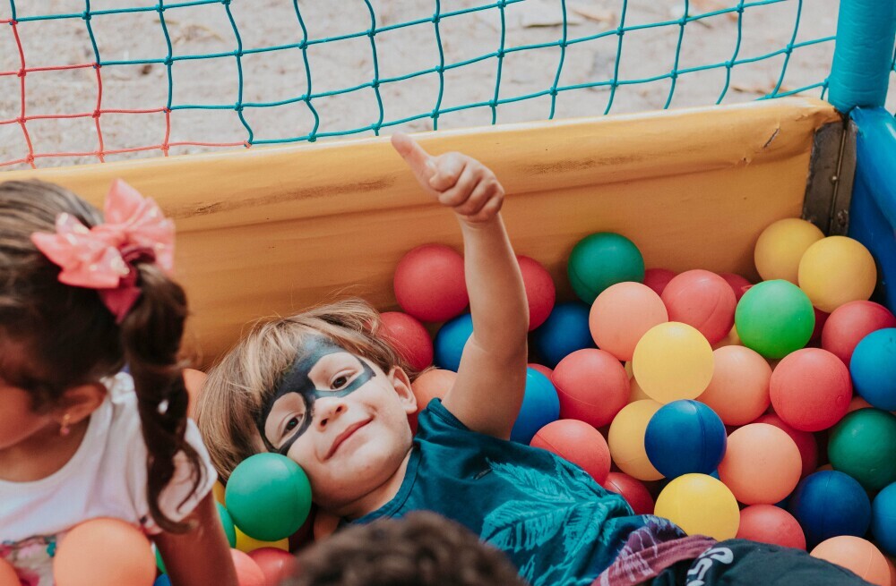 a happy child playing in a ballpit