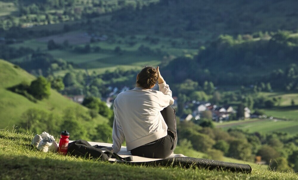 woman sat on a hilltop surveying the view