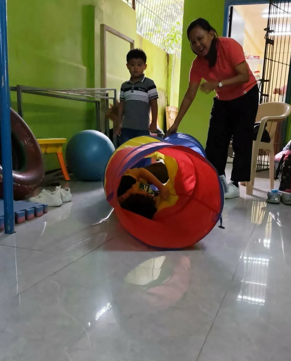 Special child in play therapy area with SPED teacher Special child in play therapy area with SPED teacher