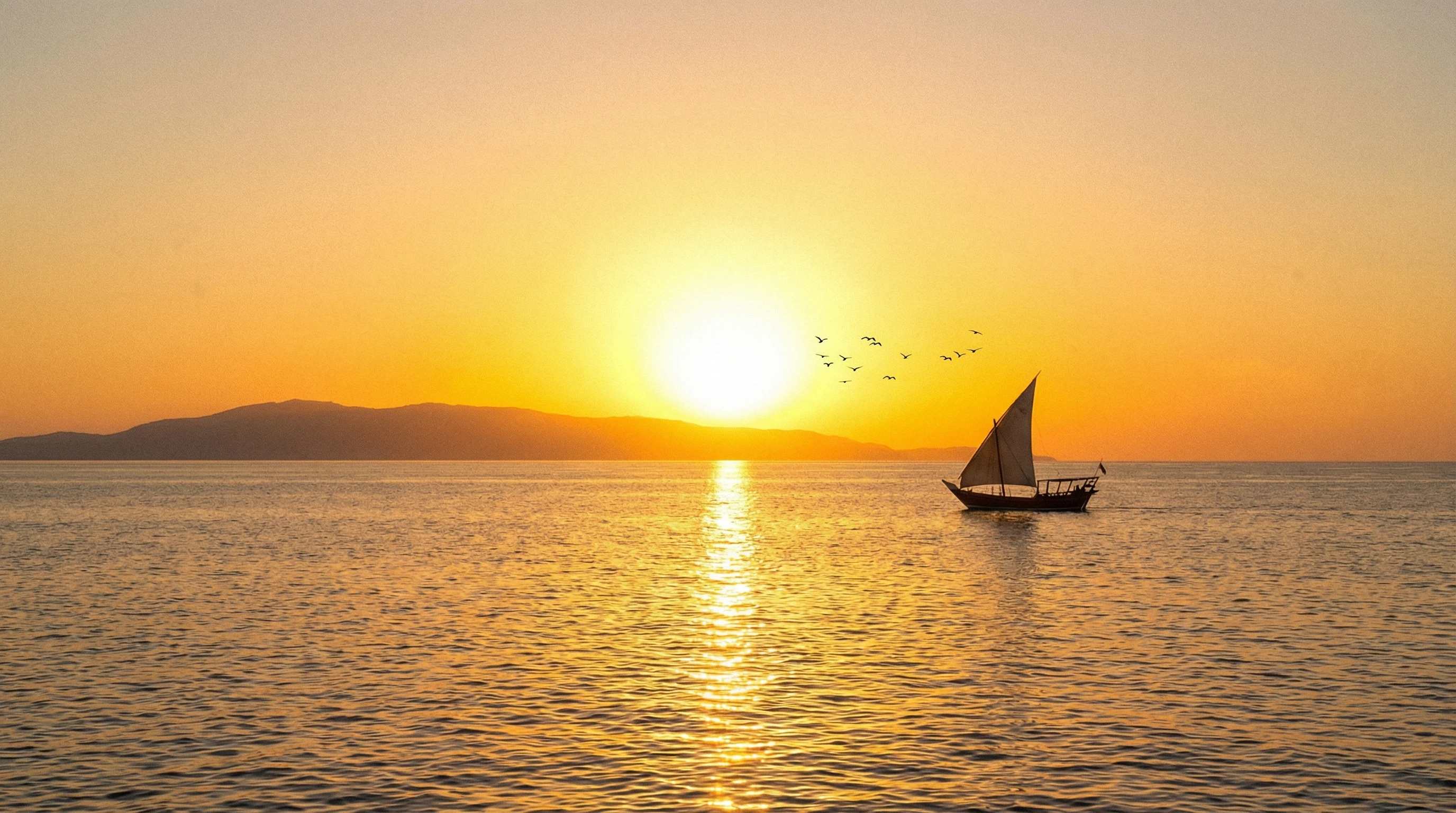 Sunrise over a calm sea with distant land, symbolizing new beginnings