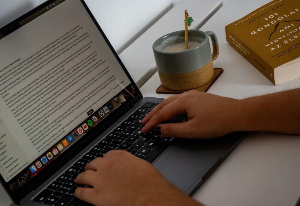 Beginner affiliate marketer writing first blog post on a laptop, focused and slightly unsure but taking action in a calm workspace