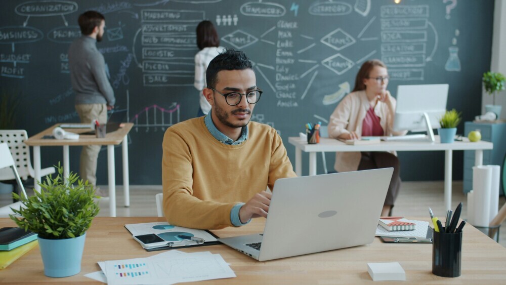 Affiliate marketer planning long-term website growth strategy. A focused digital entrepreneur planning long-term website goals with a laptop, notebook, and growth charts, calm and strategic workspace. 