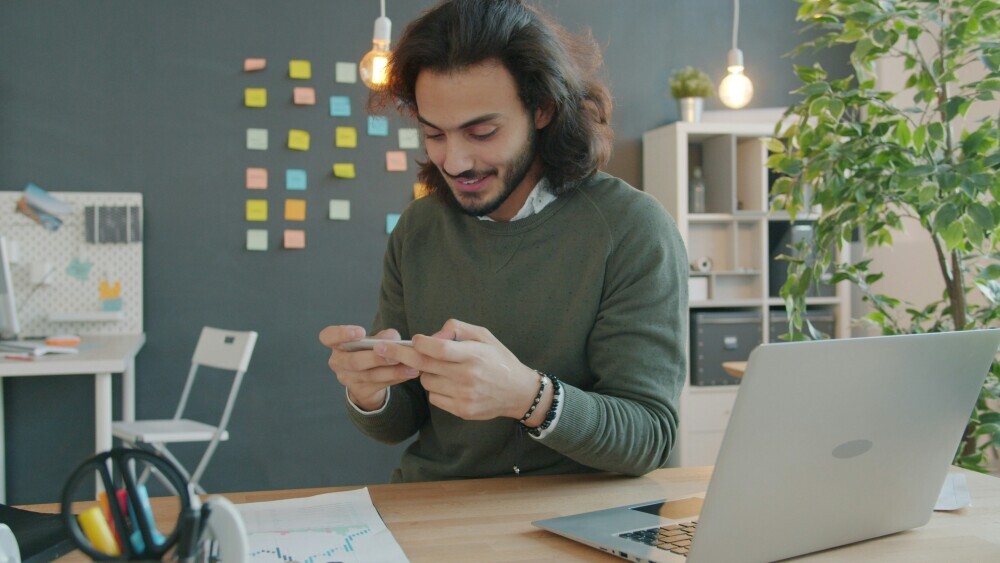 A content creator excitedly looking at a sudden increase in website traffic on analytics dashboard, upward graph visible, emotional breakthrough moment