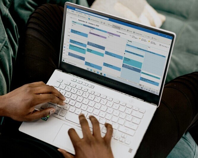 Affiliate marketer planning and managing time effectively, working on a laptop with a clear schedule and organized tasks
