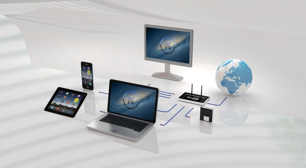 image showing display of a computer monitor, globe, router, a laptop, an ipad and a cellphone, all connected to a same website page.