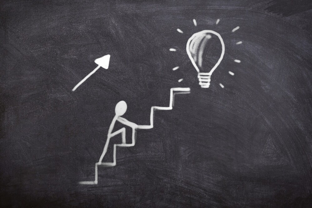 Image of a symbol showing a man taking one step at a time and progressing upward representing a step by step guide to website development.