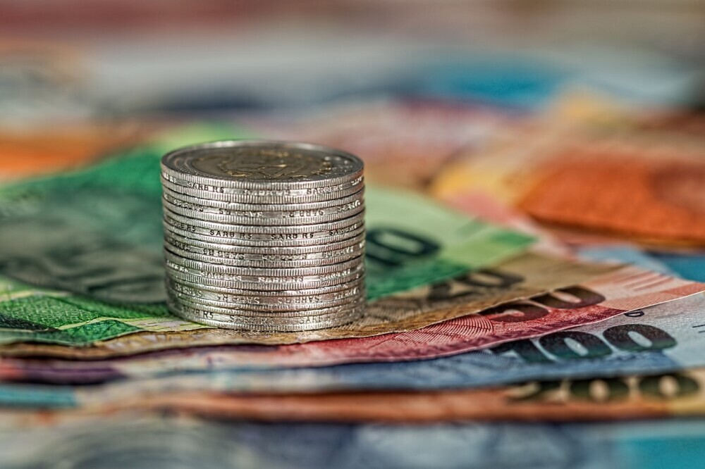 image of stacks of coins place on notes showing the hard cost of buying a home and land.