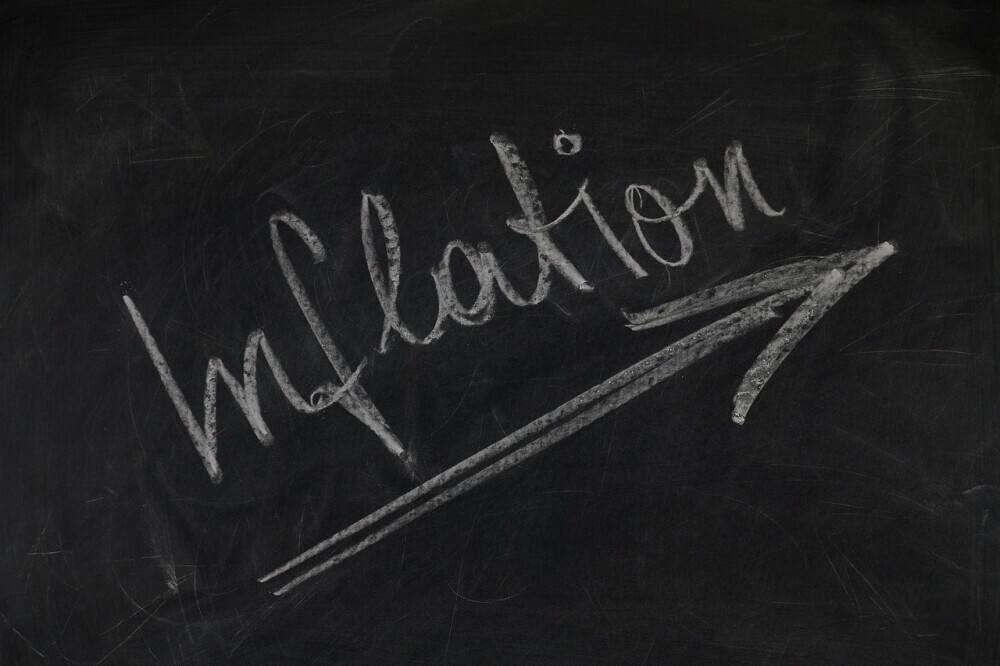 image of a blackboard with the word inflation written on it with arrow pointing up to show the increasing inflation in Papua New Guinea.