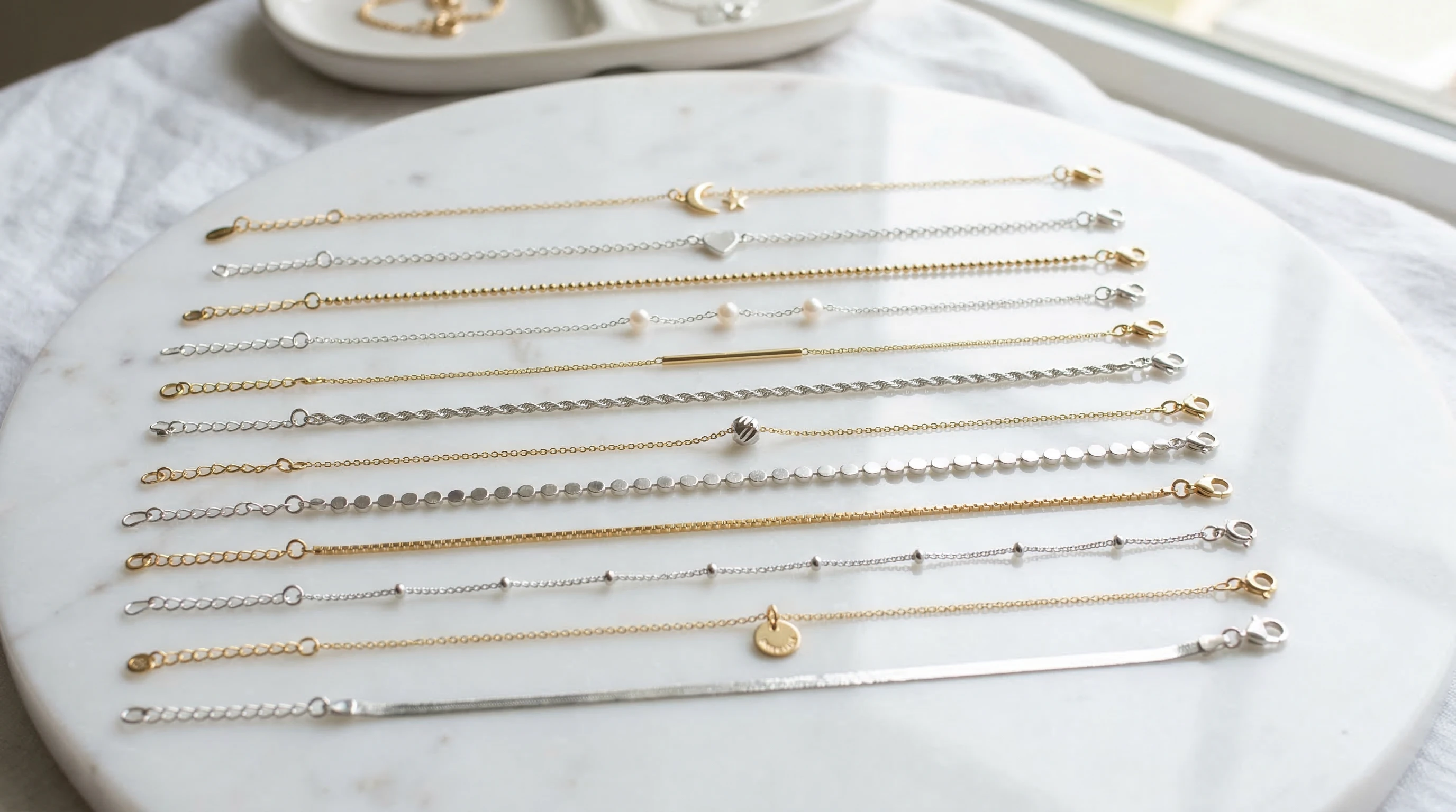 Thin gold and silver anklets laid out neatly