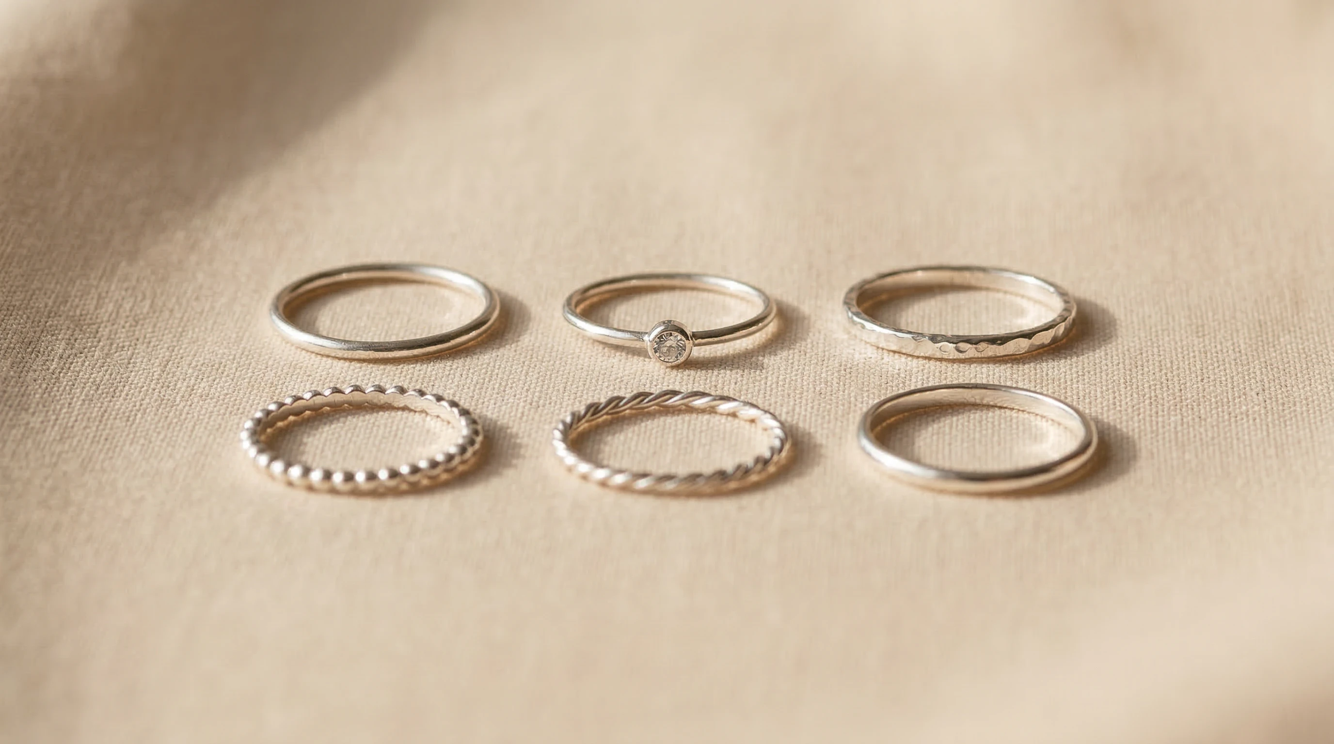 Selection of metallic toe rings on a plain background