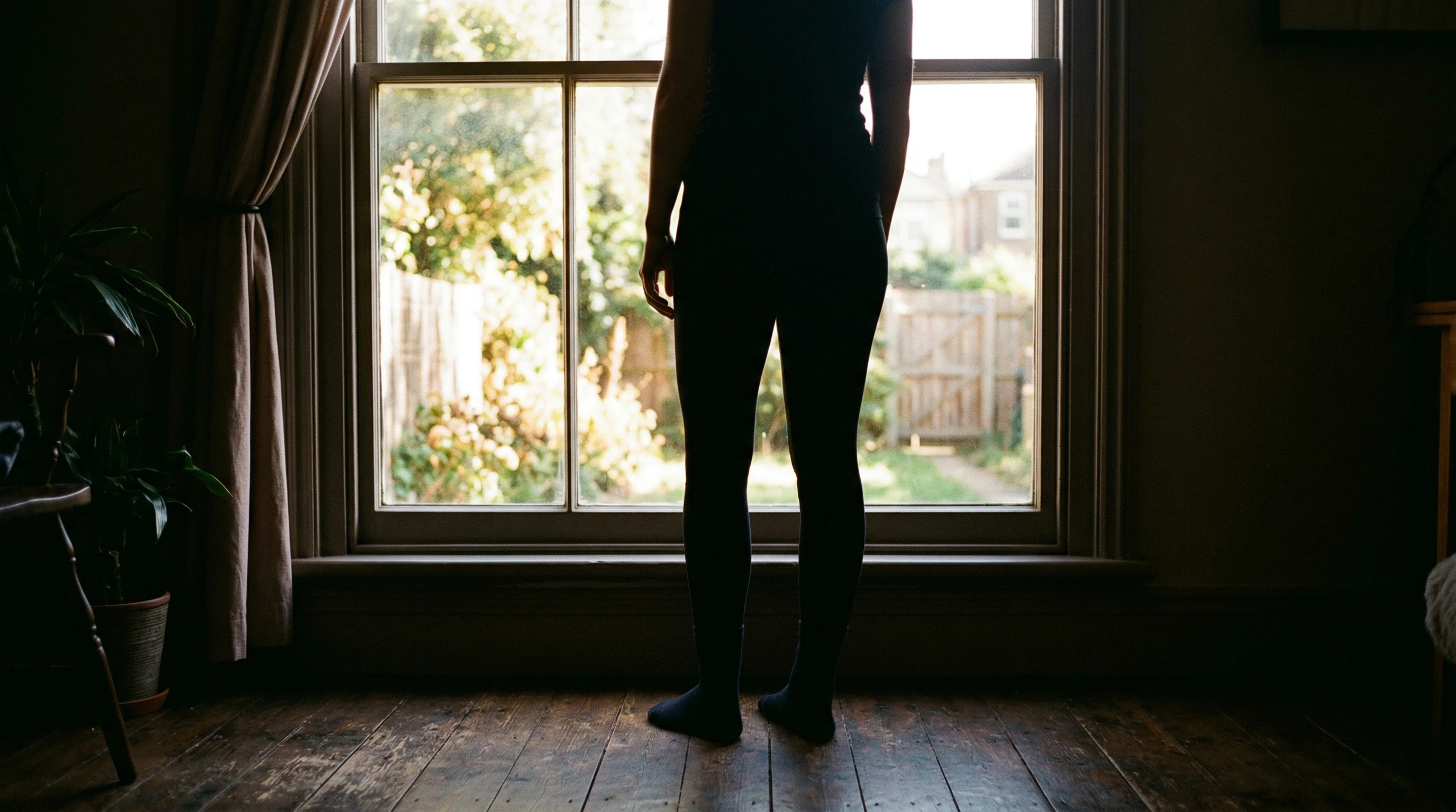 Stocking feet silhouette by bright window