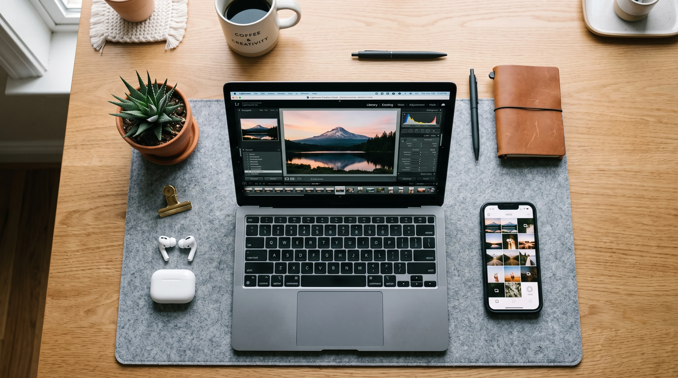 Closeup of a digital workspace with a smartphone and laptop showing foot photo editing apps open, surrounded by ambient light and natural decor.