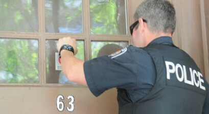 police officer knocking on door to a home