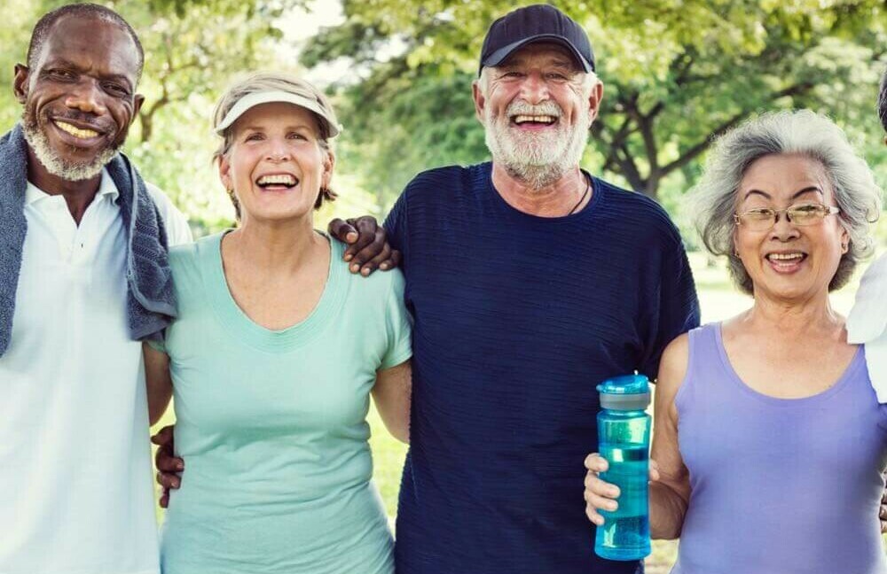 two healthy, happy senior couples out for a brisk walk