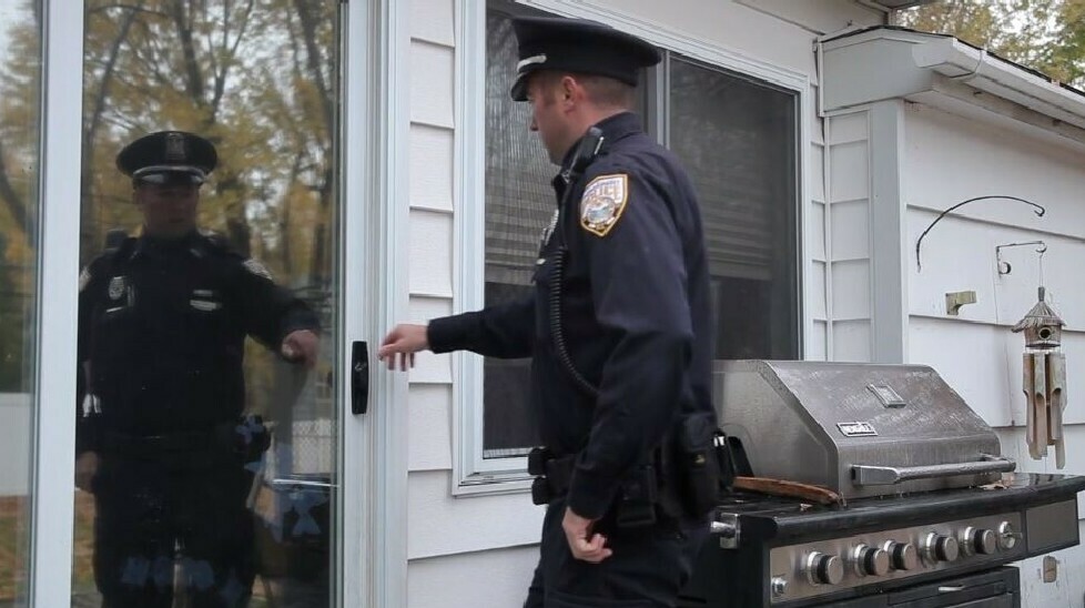 police officer at door to a home