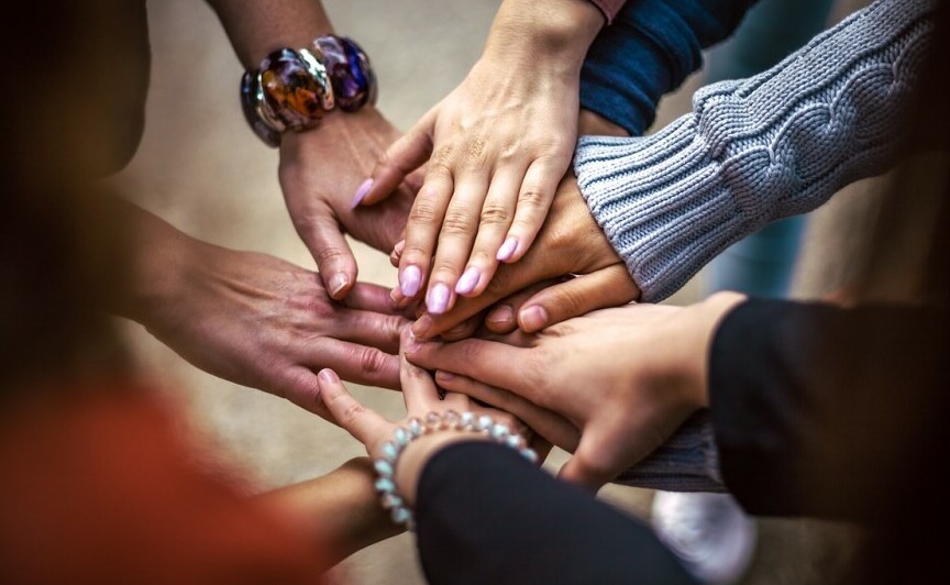 group of people putting their hands together