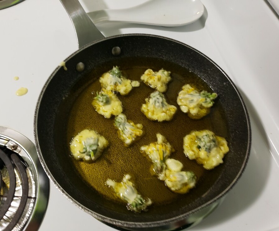 dandelion flowers fritters frying in the pan