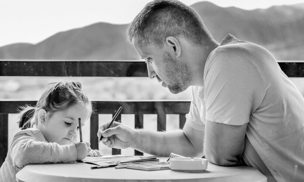 father coloring with young daughter