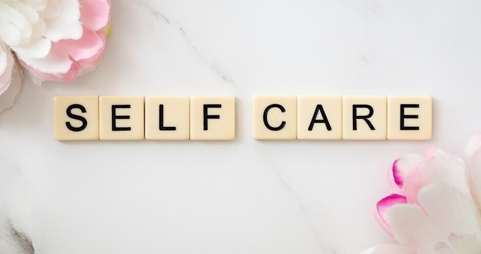 scrabble letters spelling out self care