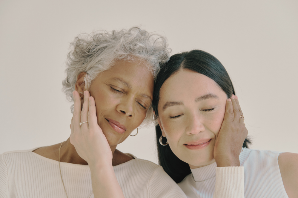 Two women feeling each others' cheeks