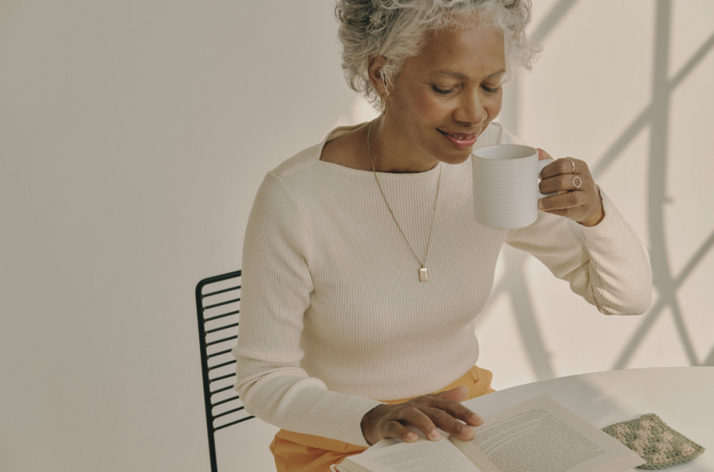 Libra season is about mindful decision making (woman sipping from her cup while reading)