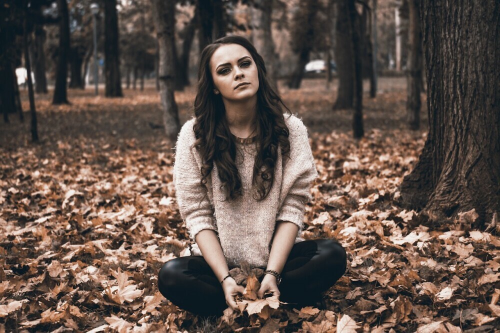 a yound woman destressing in nature on a fall day