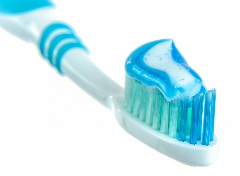 some blue and white toothpaste on a toothbrush with a white background