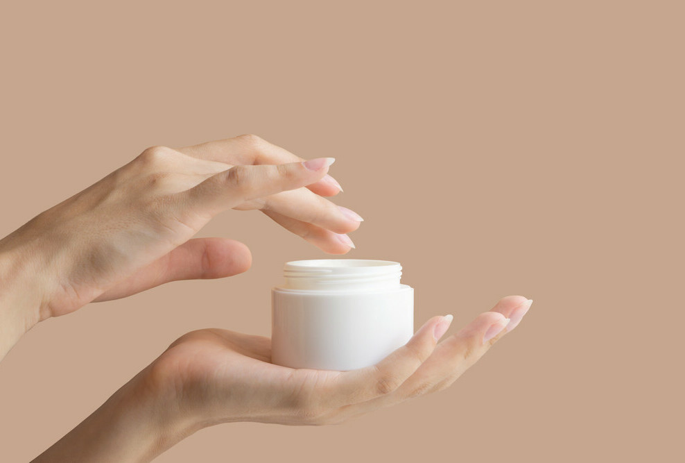 youthful hands holding jar of skincare product