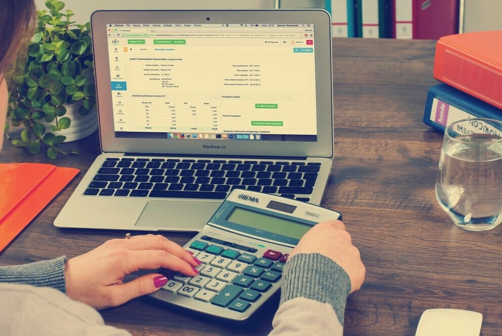 bookkeeping on a laptop with a calculator