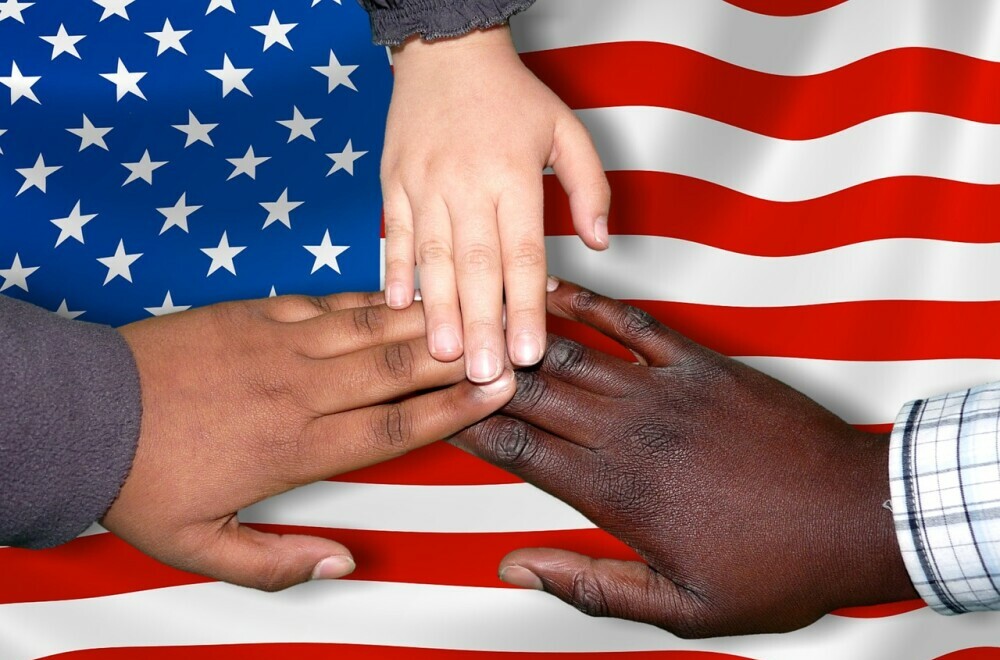 US flag with 3 different coloured hands on it