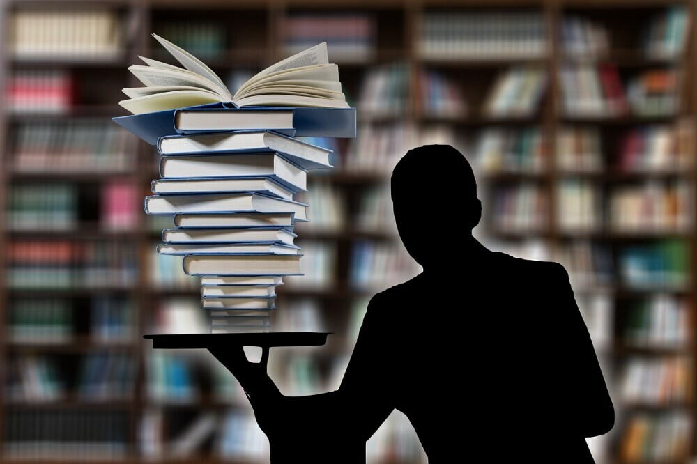 man holding a pile of books