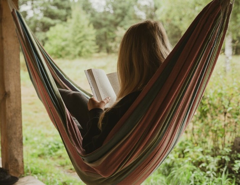 Reading in a backyard hammock