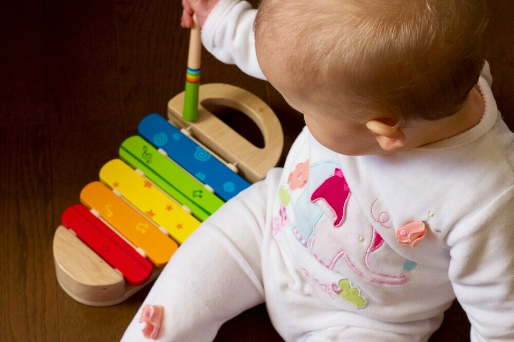 Baby Playing with Wooden Xylophone