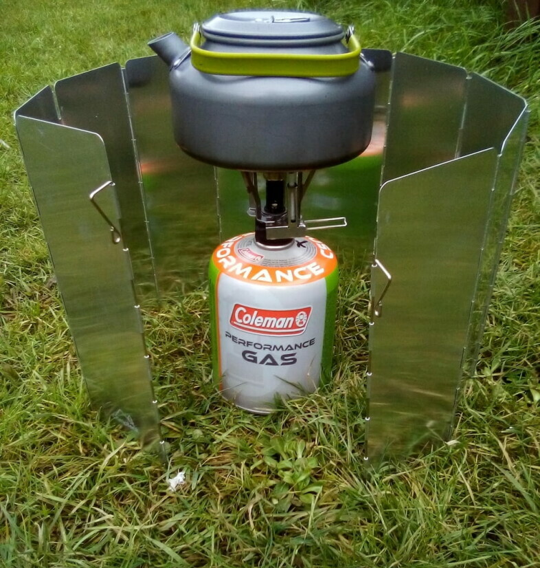 Camping windshield around a camping stove and kettle