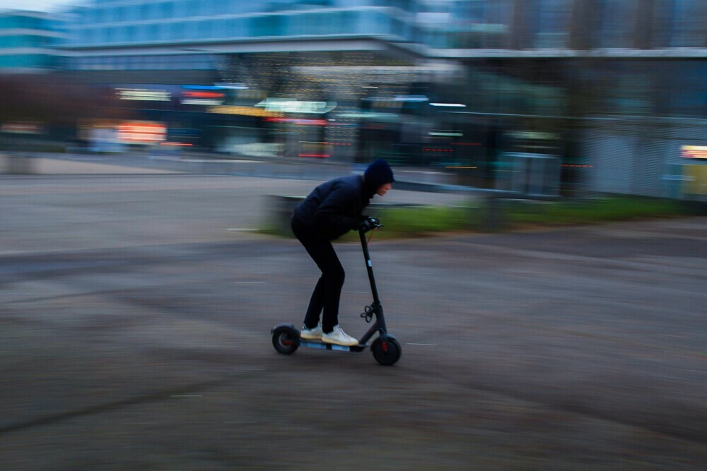 Individual riding through urban area on their electric scooter