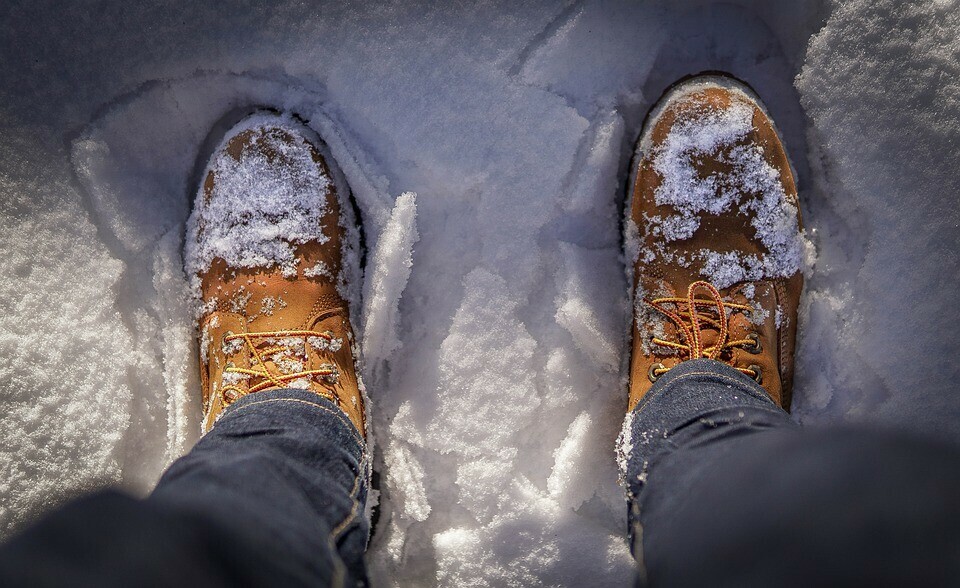 Individual standing in snow wearing Timberland boots