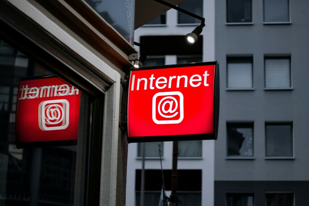 Image of a red sign with the word Internet in white lettering outside a cafe