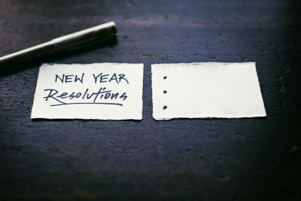 Image of two pieces of paper, one reading New Years Resolution with a pen nearby