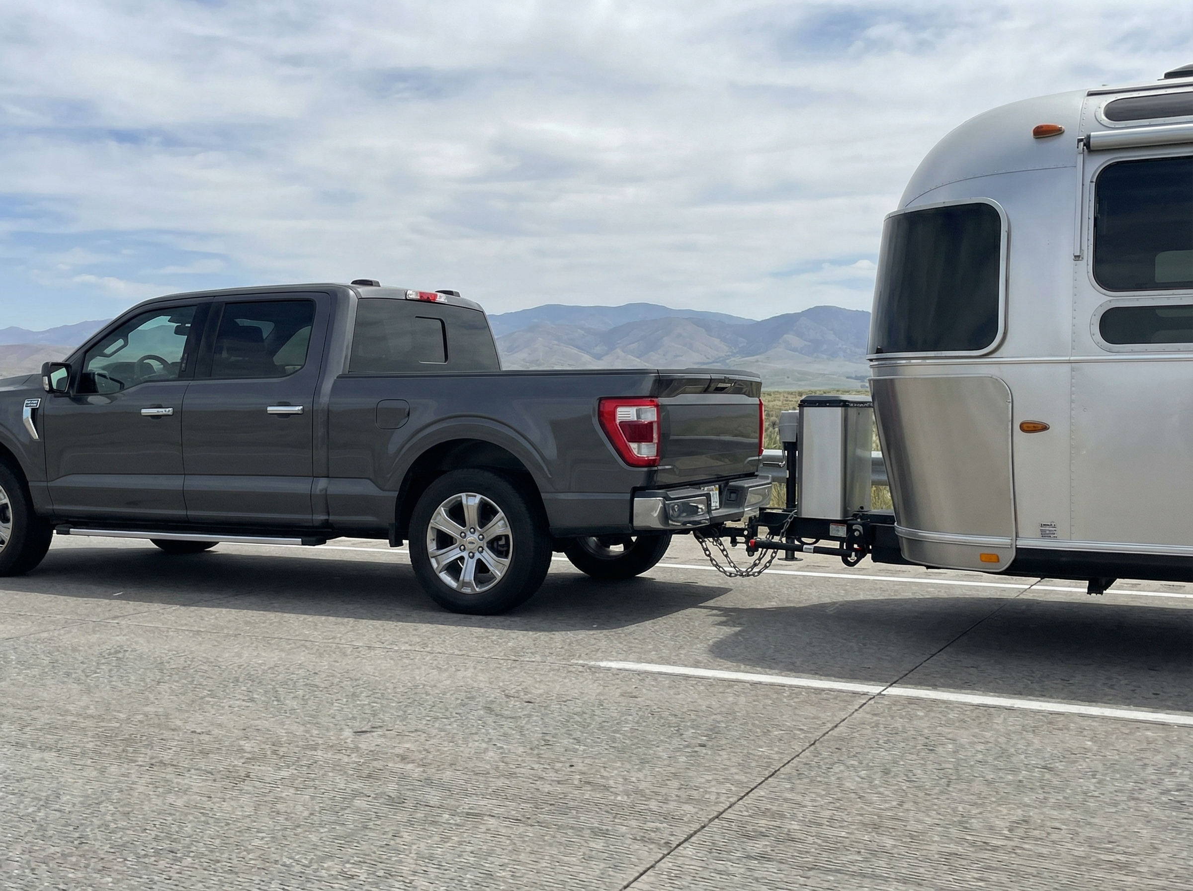 Half-ton truck towing a travel trailer on the road