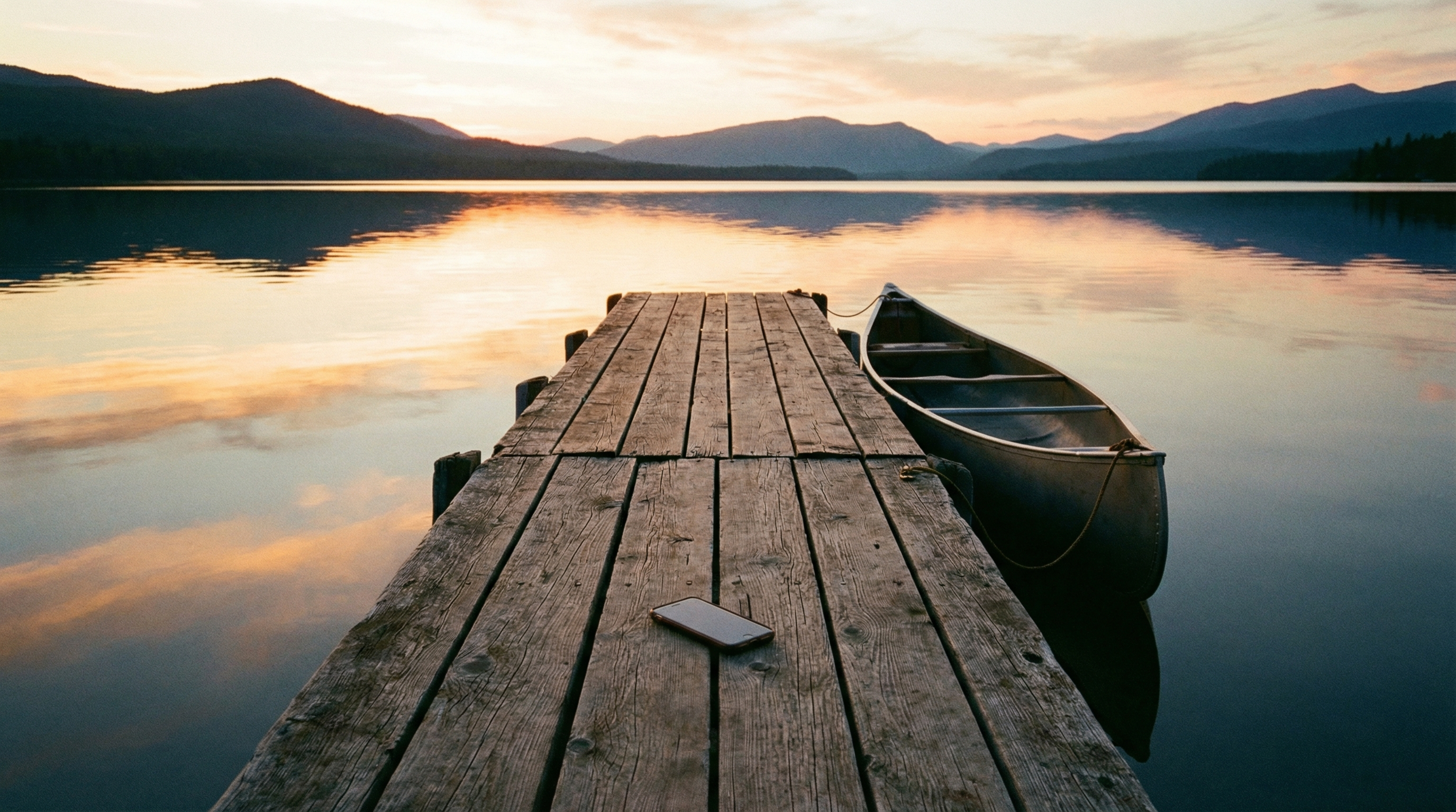 Wooden dock at sunset with phone face down