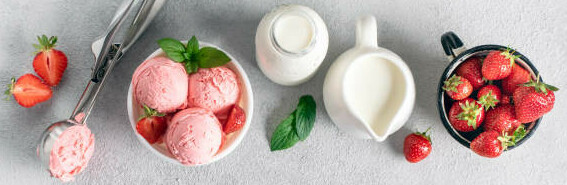 Low-Calorie Homemade Ice Cream For Guilt-Free Indulgence image 4 top view fresh strawberries strawberry ice cream with ice cream scoop and jugs of cream and milk plus fresh green leaves frosted fusions