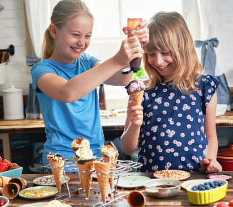 Classic Ice Cream Desserts image 10 to girls laughing and having fun with an array of ice cream ingredients around them frosted fusions