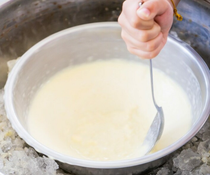 Why Is My Homemade Ice Cream So Hard image 9 bowl of rock solid ice cream with someone holding a spoon trying to dig in frosted fusions