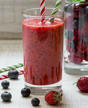 The Power Of Fat-Burning Smoothies image 5 berry blast smoothie in glass with straws and selection of berries scattered around frosted fusions