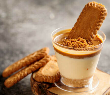 Churn Up the Fun Homemade Biscoff Ice Cream image 2 biscoff biscuits with a glass of coffee dessert one biscuit dunked in dessert frosted fusions 
