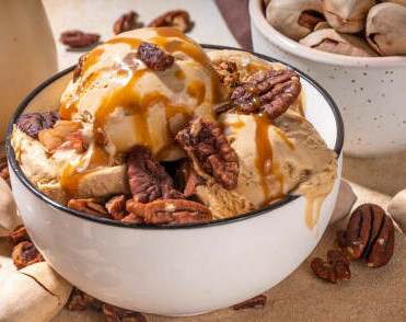 Thanksgiving Treats Homemade Ice Cream Treats to Sweeten Your Celebration image 4 scoops of brownbutter and boubon ice cream topped with pecans and drizzled with a caramel sauce frosted fusions