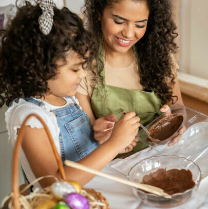 Easter Eggs-travaganza Homemade Easter Egg Ice Cream Ideas image 5 woman and child making easter eggs with chocolate and moulds frosted fusions