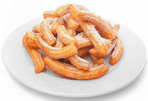 Homemade Cinnamon & Churros Ice Cream Spice and Crispy Comfort image 1 pile of churros on white plate white background frosted fusions